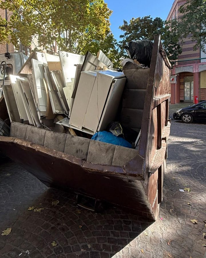 Absetzcontainer mit ausgeräumten Schränken vor einem Wohnhaus