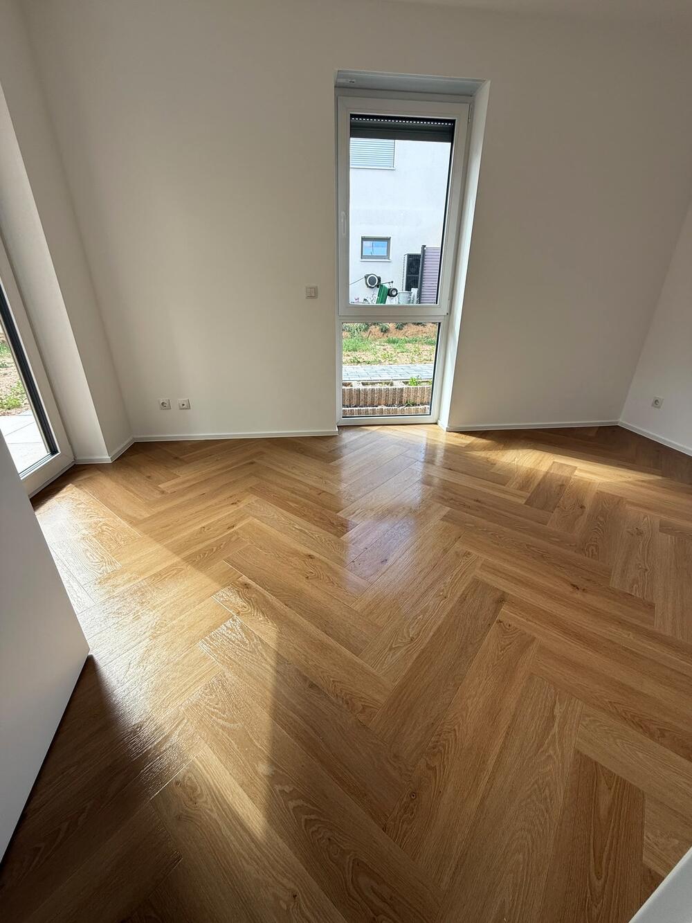 Leeres Zimmer mit Fischgrätparkett, bereit zur Übergabe